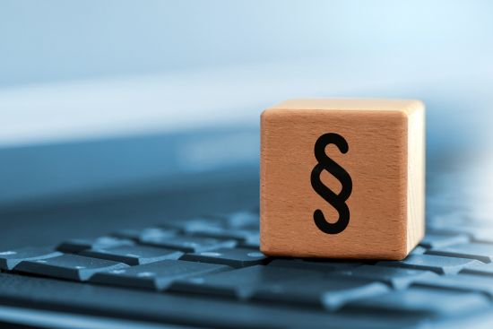 Holzwürfel mit Paragraphenzeichen auf Tastatur (Quelle: iStock) Holzwürfel mit Paragraphenzeichen auf Tastatur