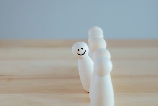 Eine Reihe von Spielfiguren, wovon eines freundlich lächelt. (Quelle: iStock) Eine Reihe von Spielfiguren, wovon eines freundlich lächelt.